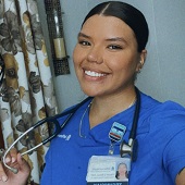 Raquel Ramos, BS health sciences `22, wearing blue scrubs holding a stethoscope.